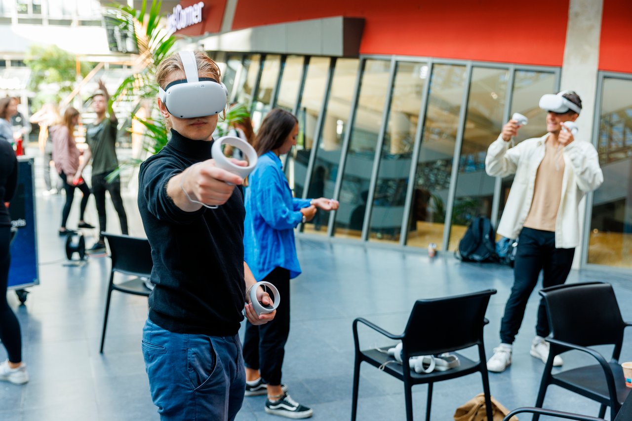 Twee studenten gebruiken VR consoles in de aula 