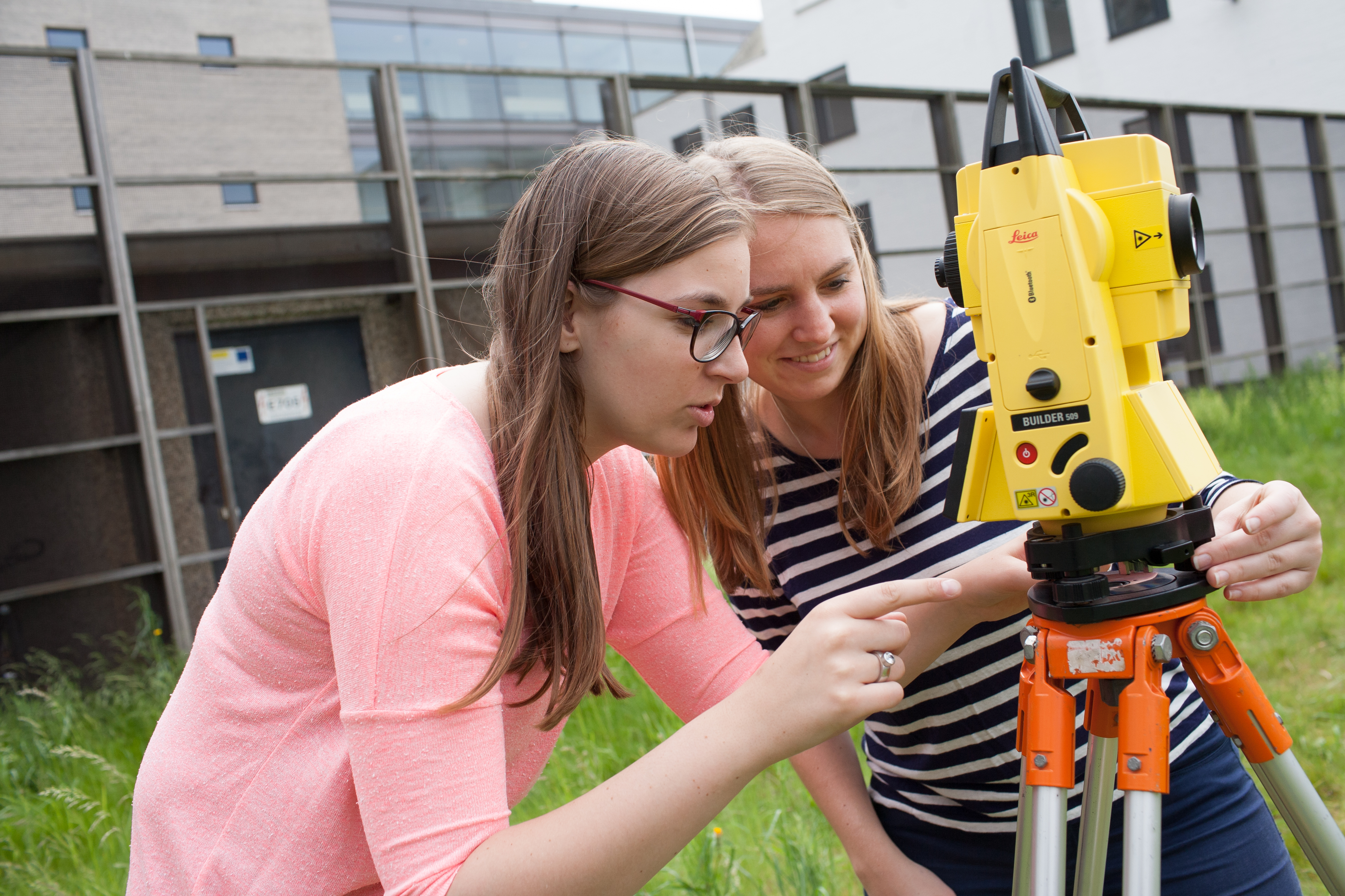 Twee studenten werken met landmeter