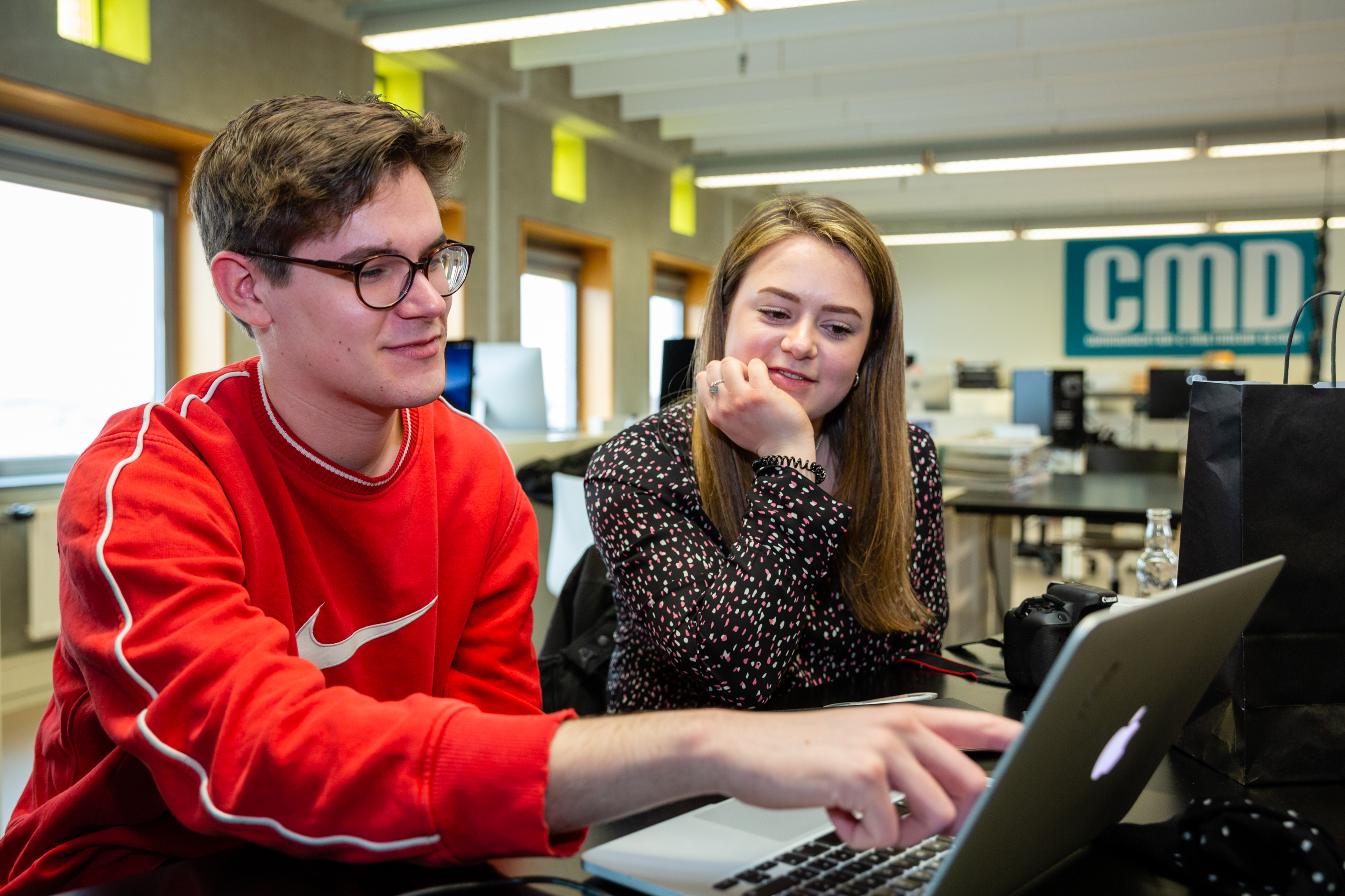 Twee studenten overleggen achter laptop
