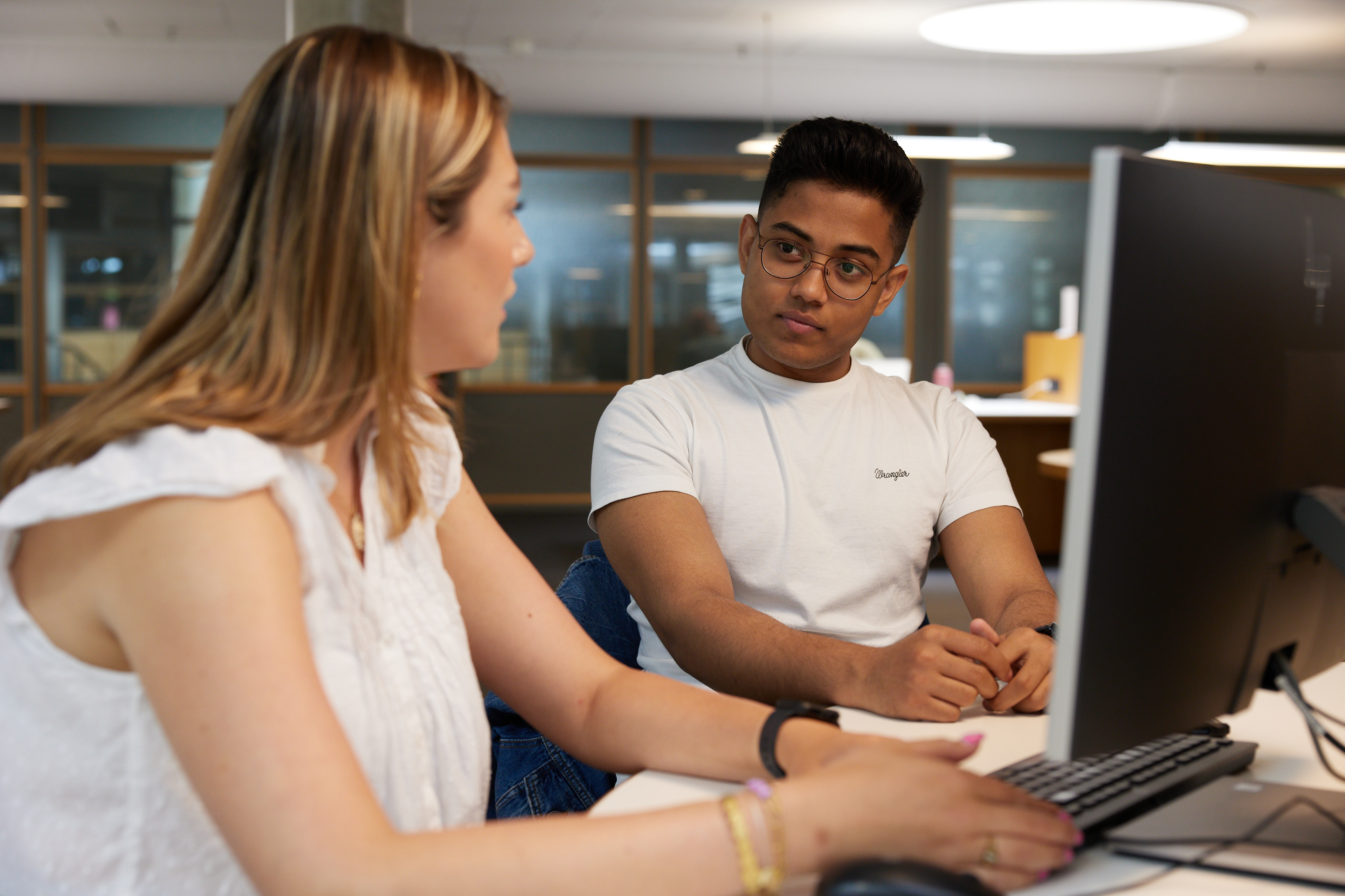 Twee studenten overleggen achter laptop