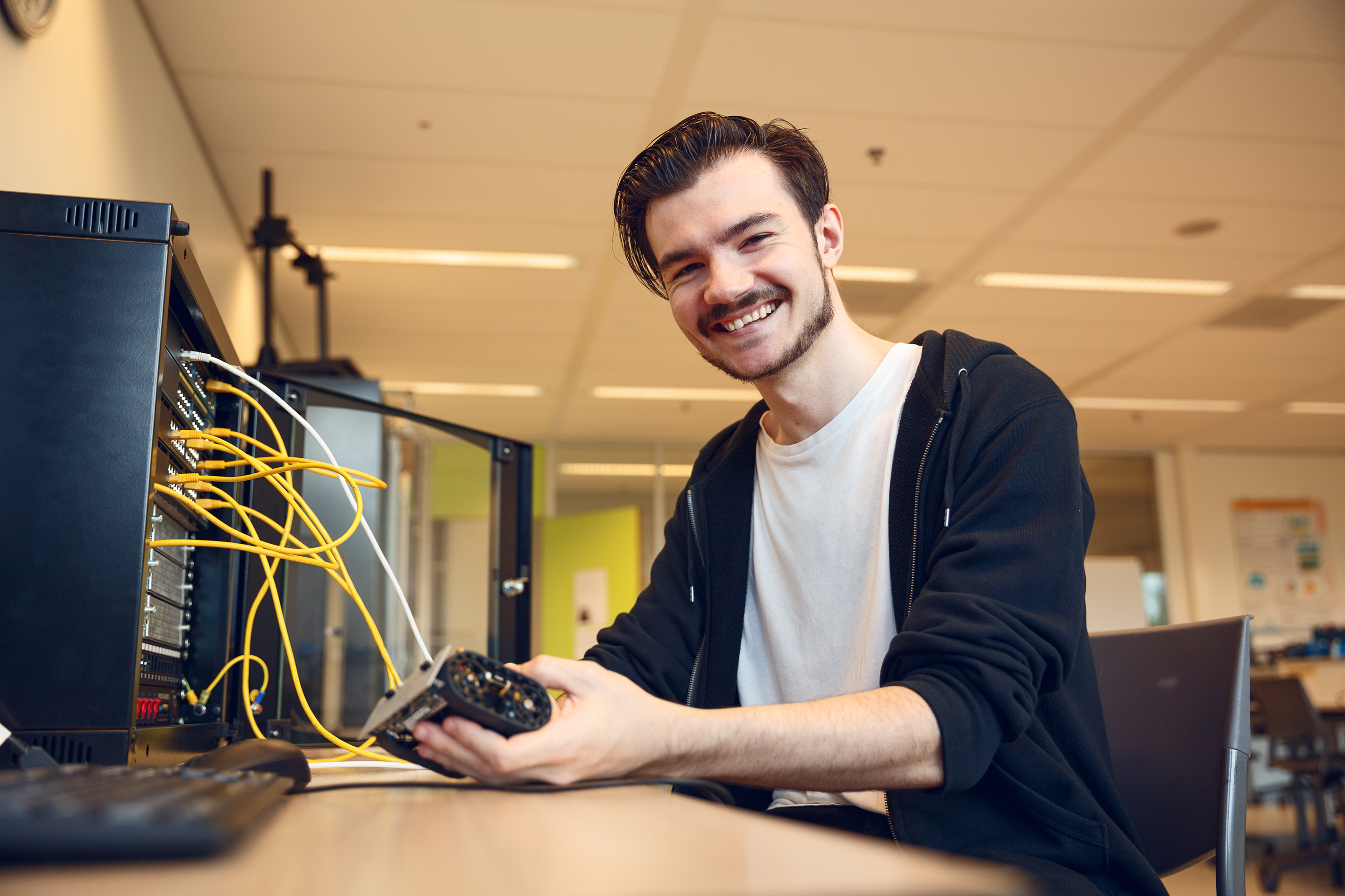 Student aan het werk met computer in praktijklokaal