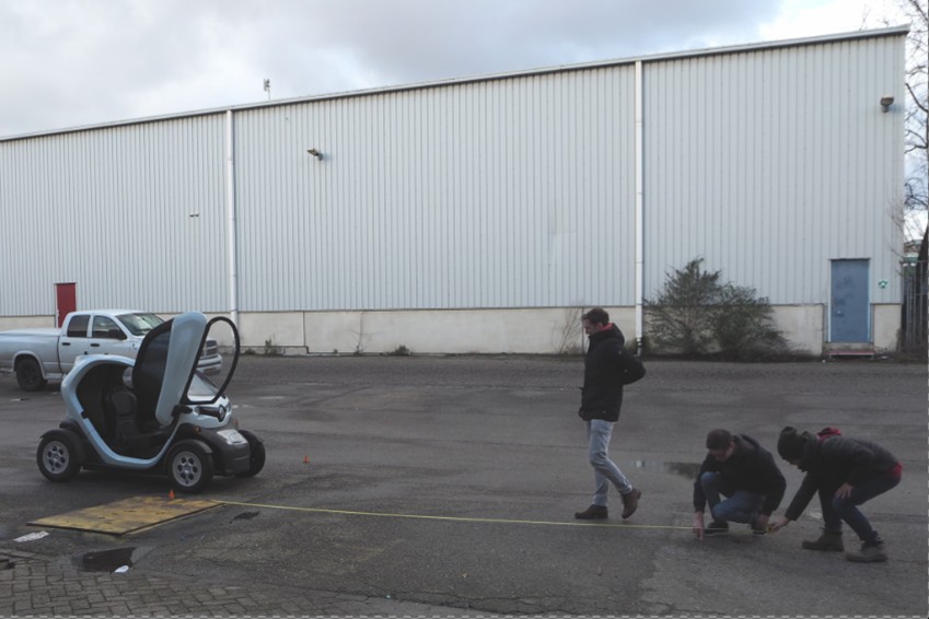 drie jongens die een test uitvoeren met een kleine auto