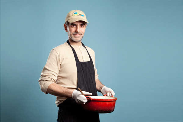 een man met en rode pan in zijn hand