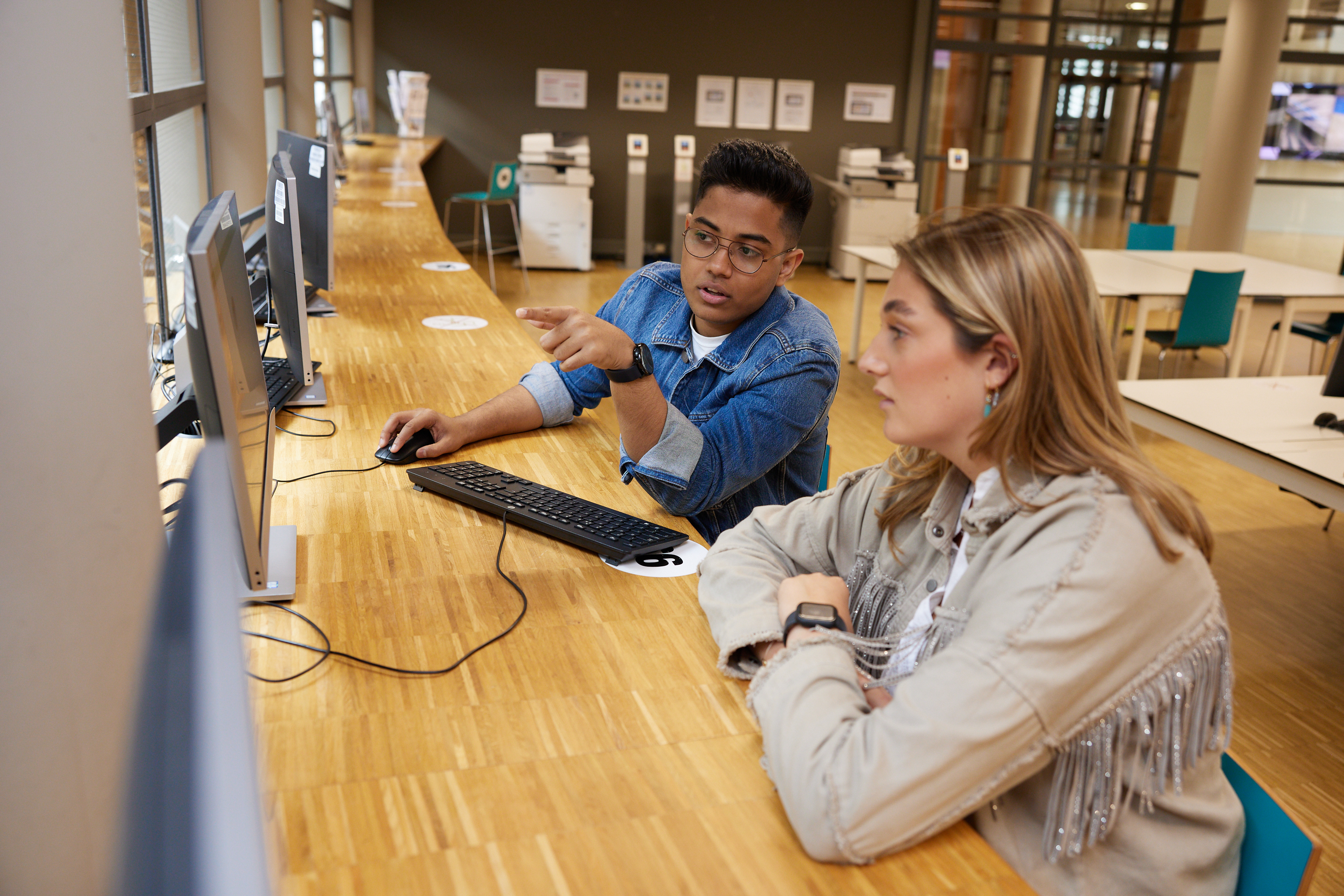 Twee studenten aan het werk achter een pc