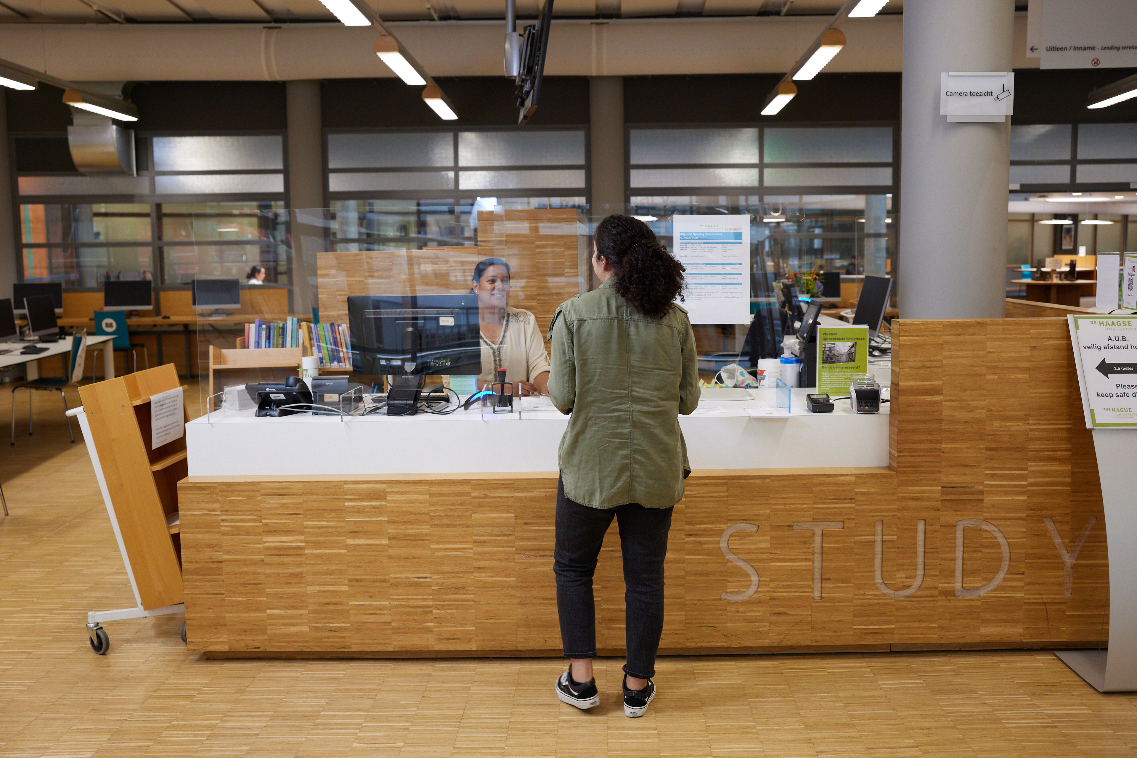 Student staat aan de balie in de bibliotheek