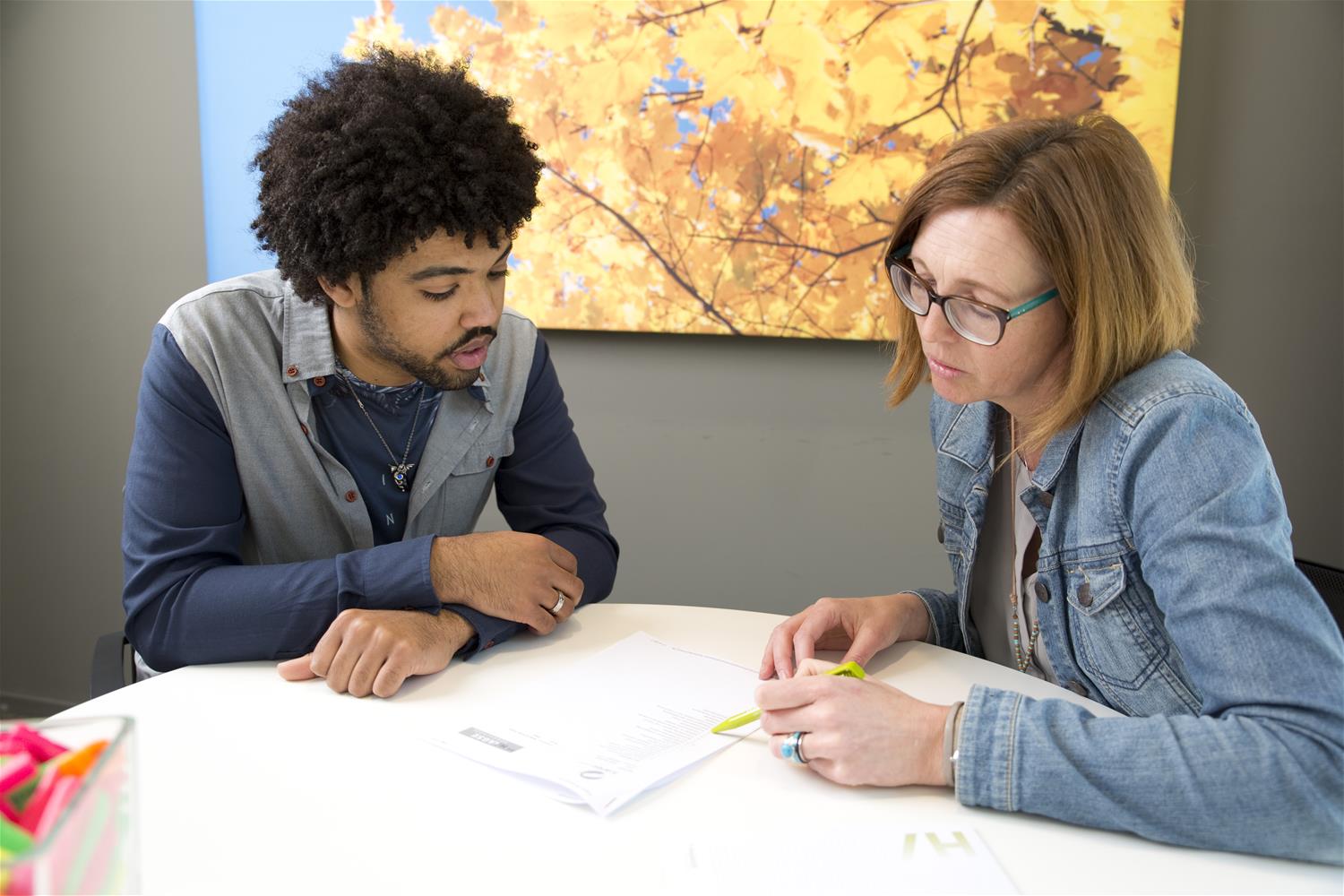 Een student die een rapport controlleert samen met een docent