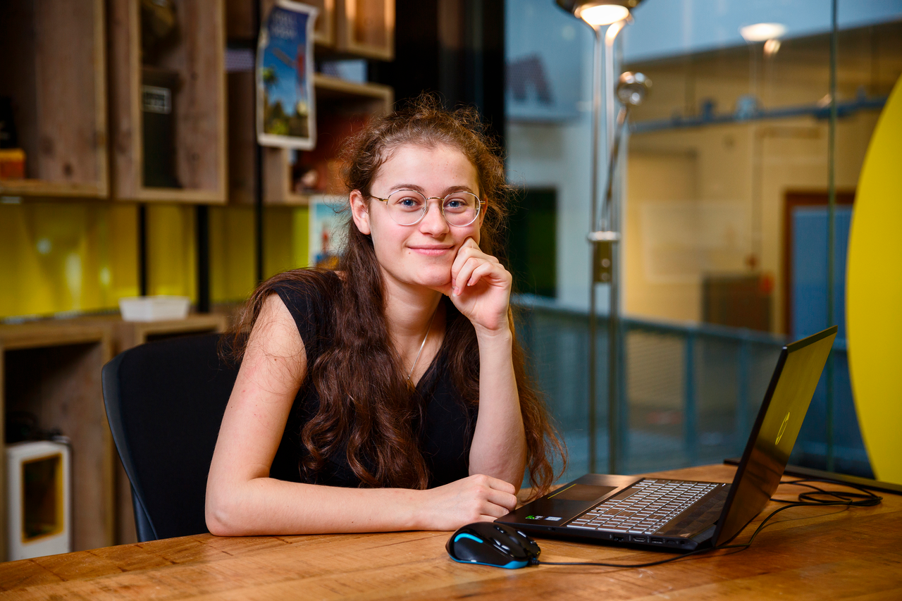 Studente achter laptop aan tafel