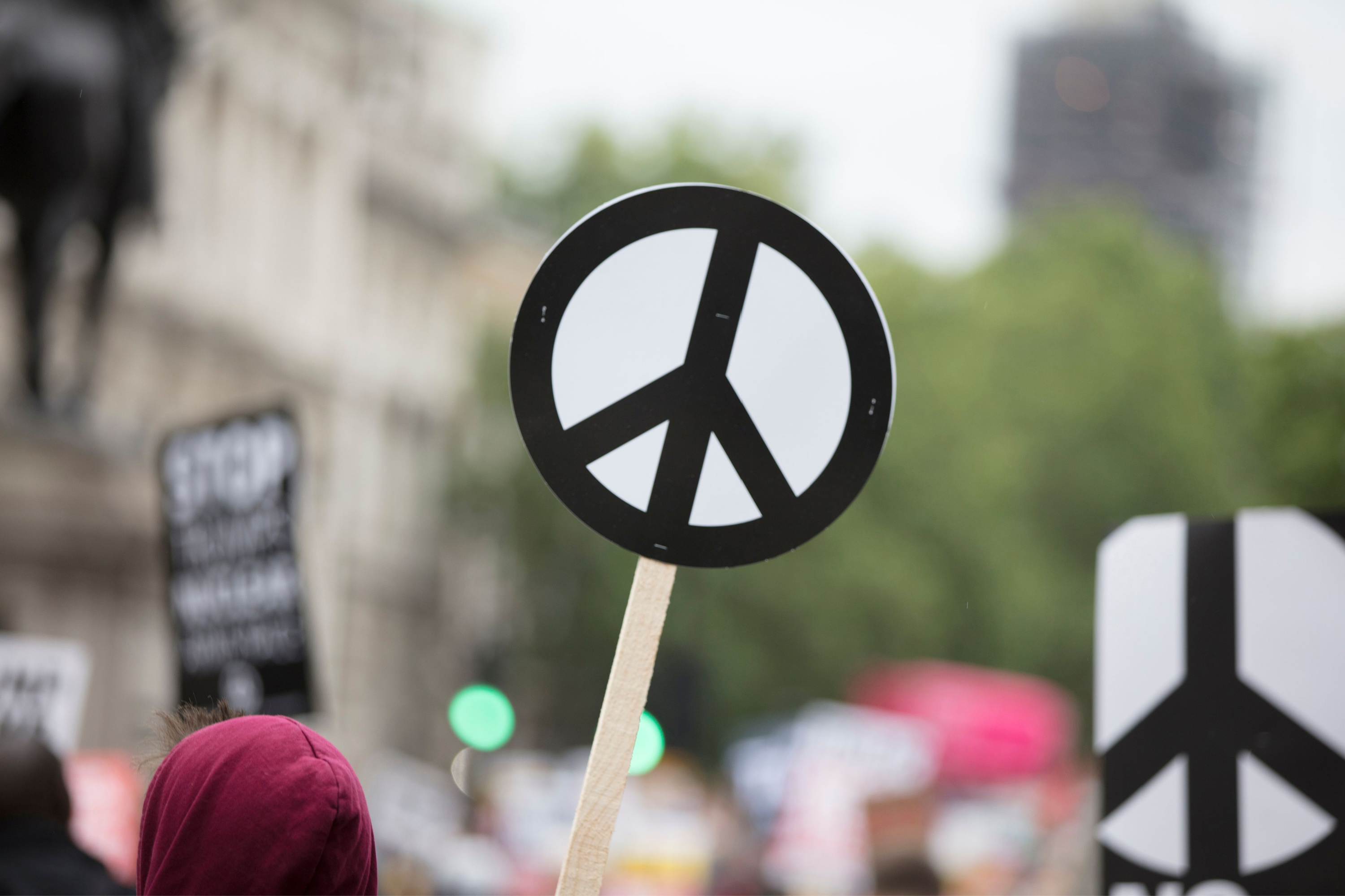 Lectoraat United Nations Studies in Peace and Justice, mensen dragen een Peace sign in een demonstratie
