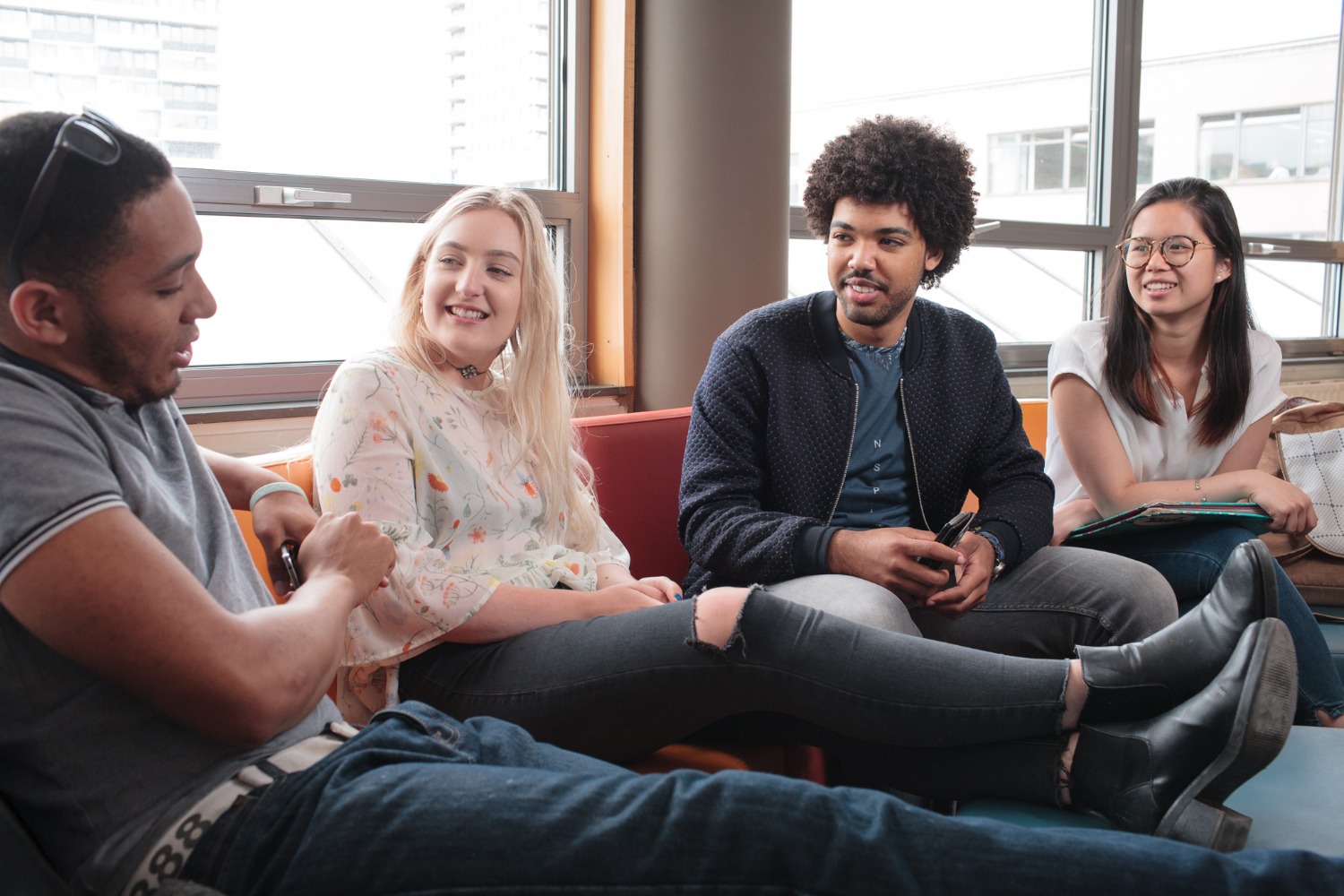 two ladies and two gentlemen sitting side by side conferring