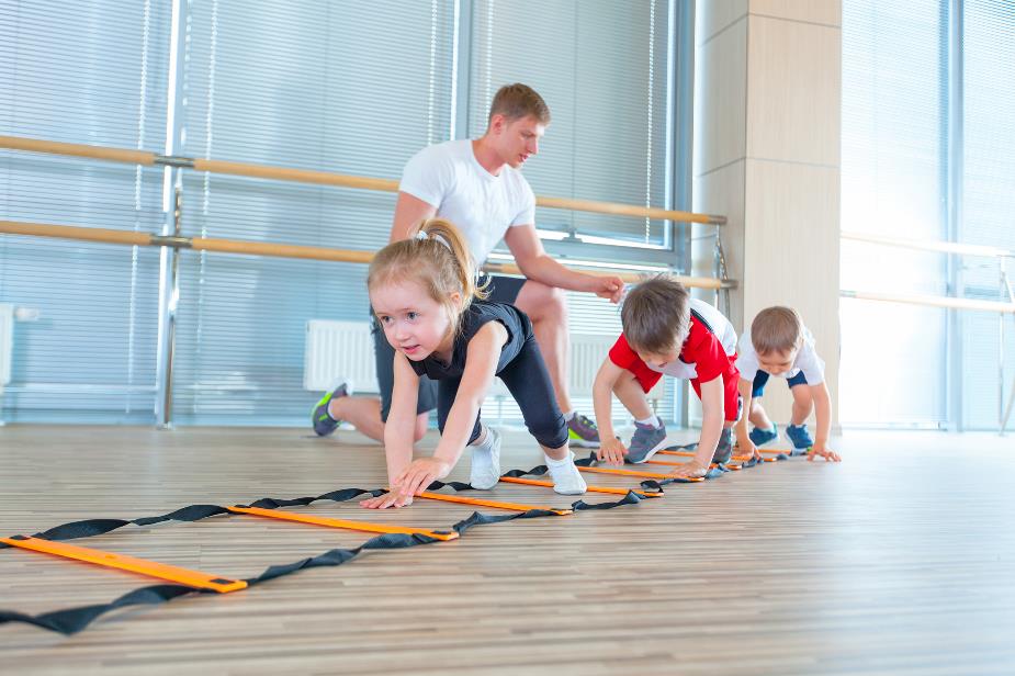 Docent geeft sport les aan kinderen