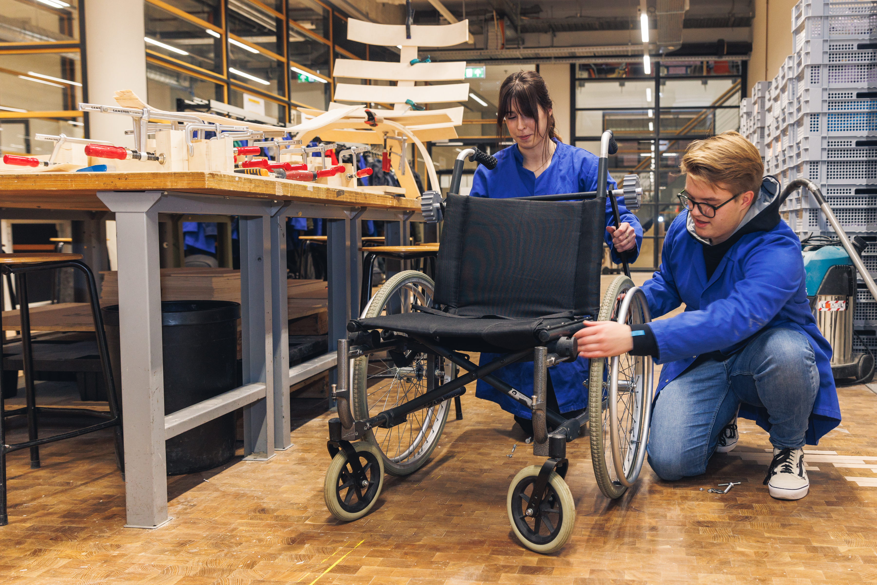 Twee studenten die aan een rolstoel werken