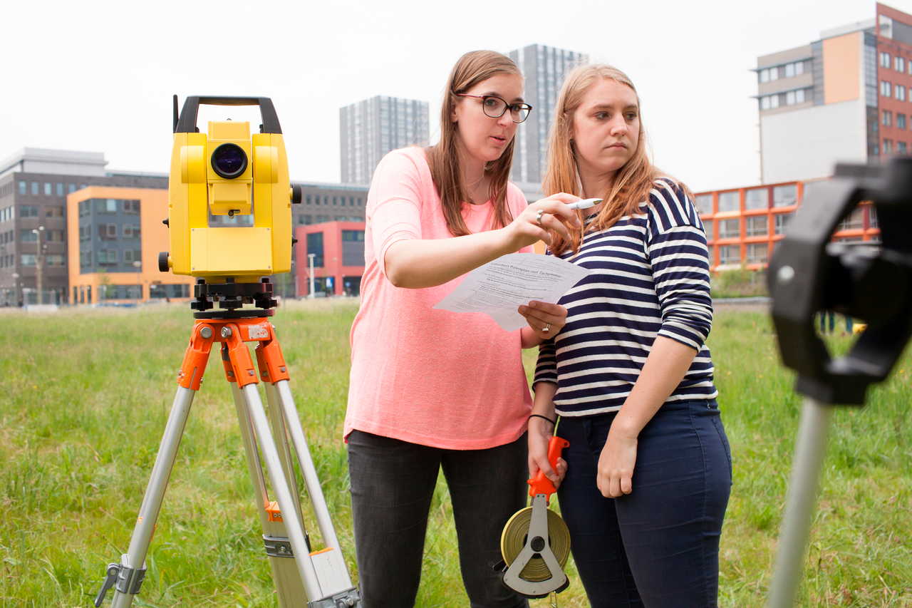 Bouwkunde studenten bij meetinstrument