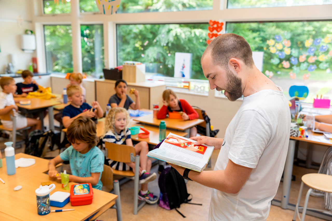 Student leest voor aan kinderen op basisschool