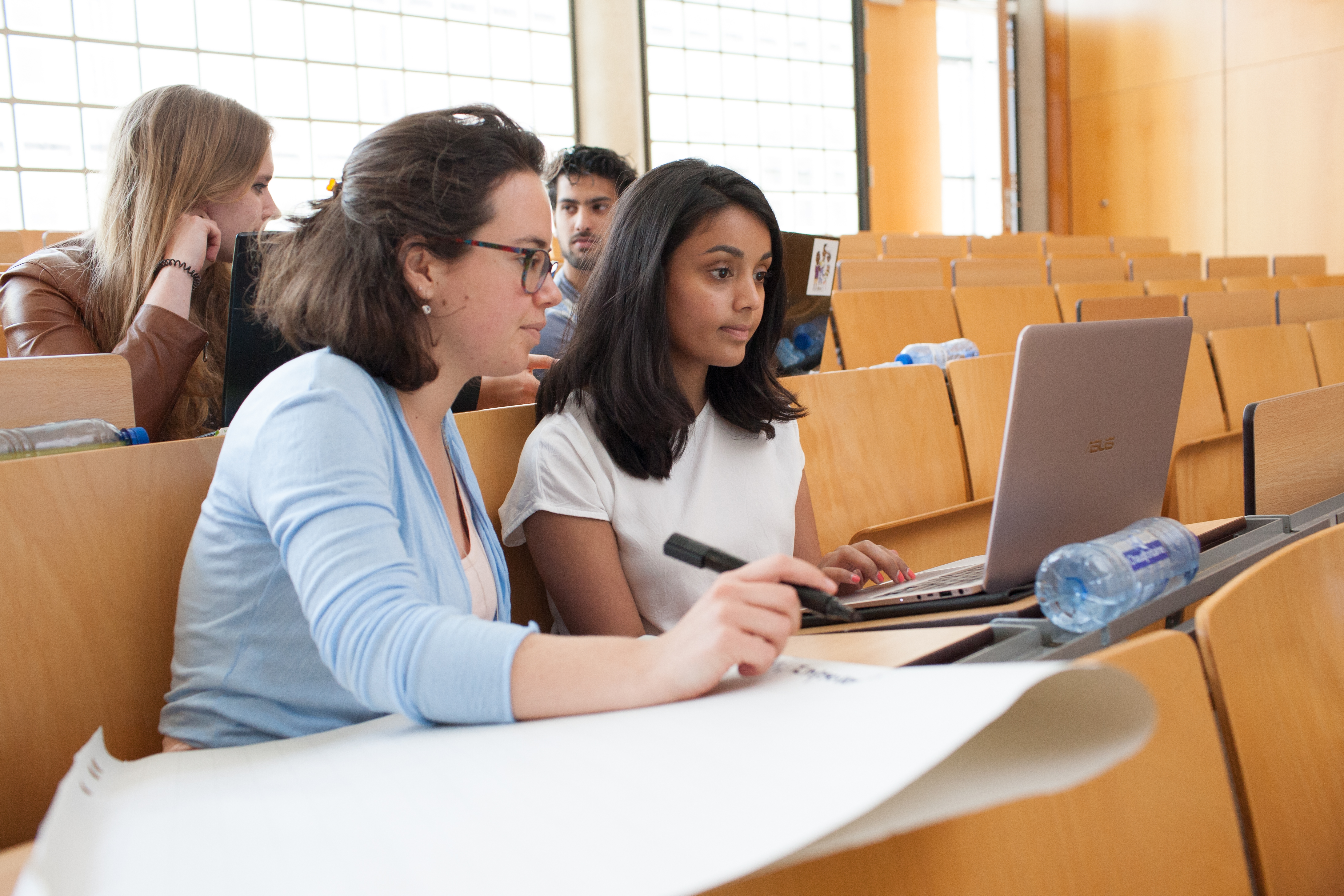 Twee studenten werken samen achter een laptop