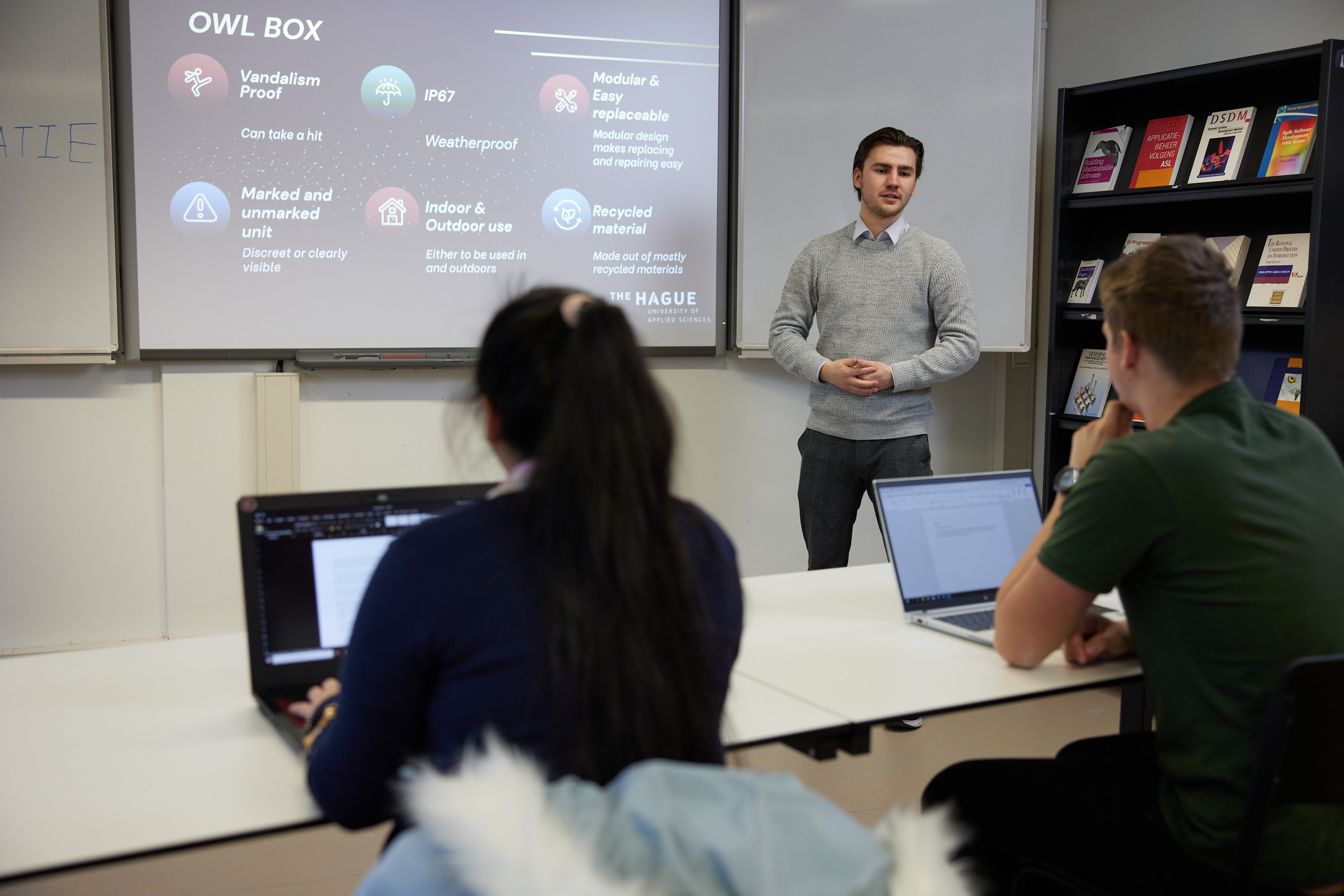 Twee studenten kijken naar presentatie student