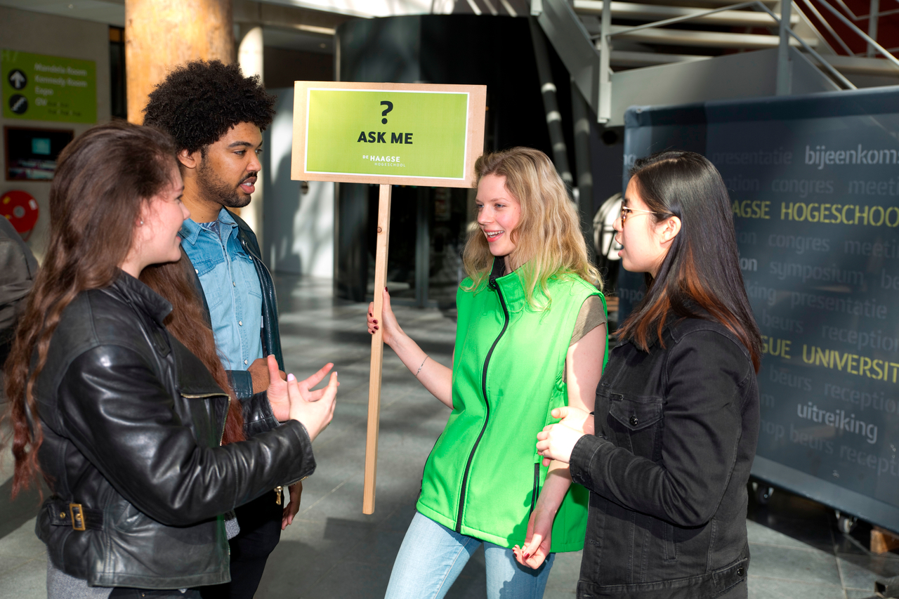 Twee aankomende studenten in gesprek met zittende studenten