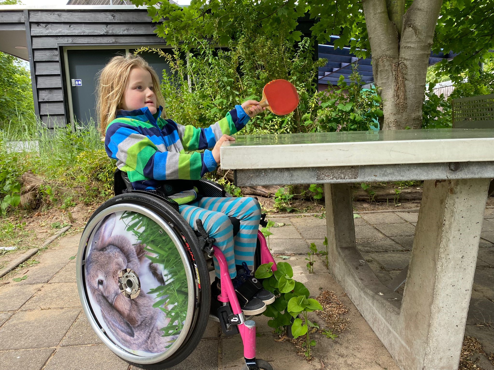 Kind in een handbewogen rolstoel 