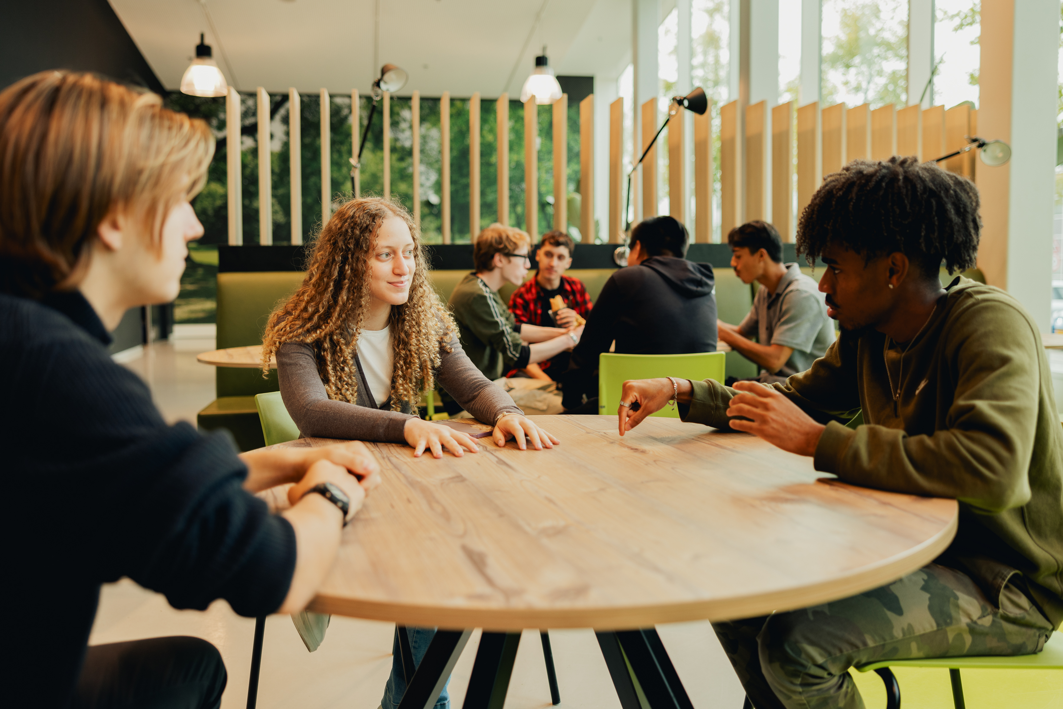 Groepje studenten overleggen aan tafel