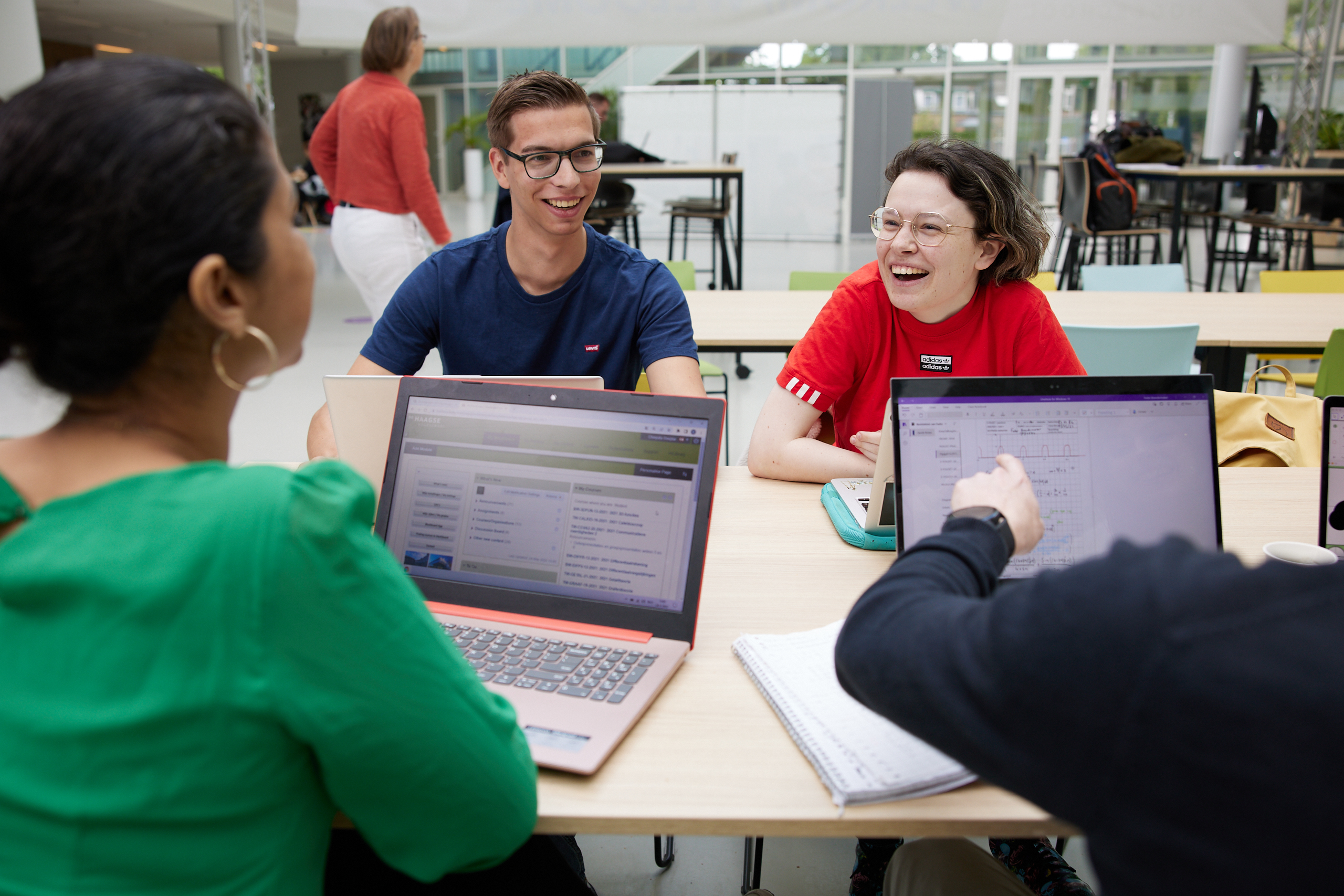 Een vrolijk groepje studenten overlegt aan tafel