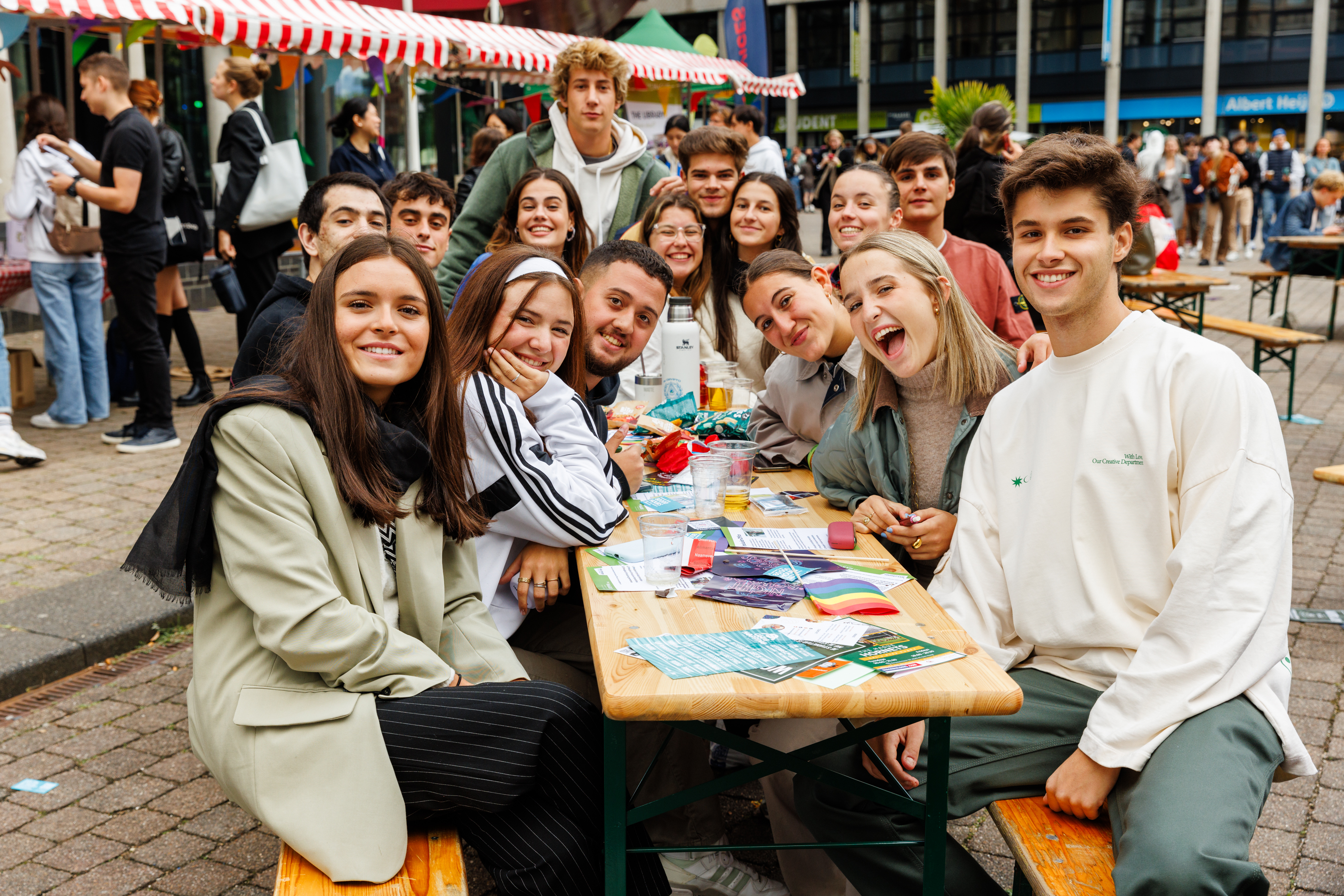 Studenten zitten samen buiten aan tafel