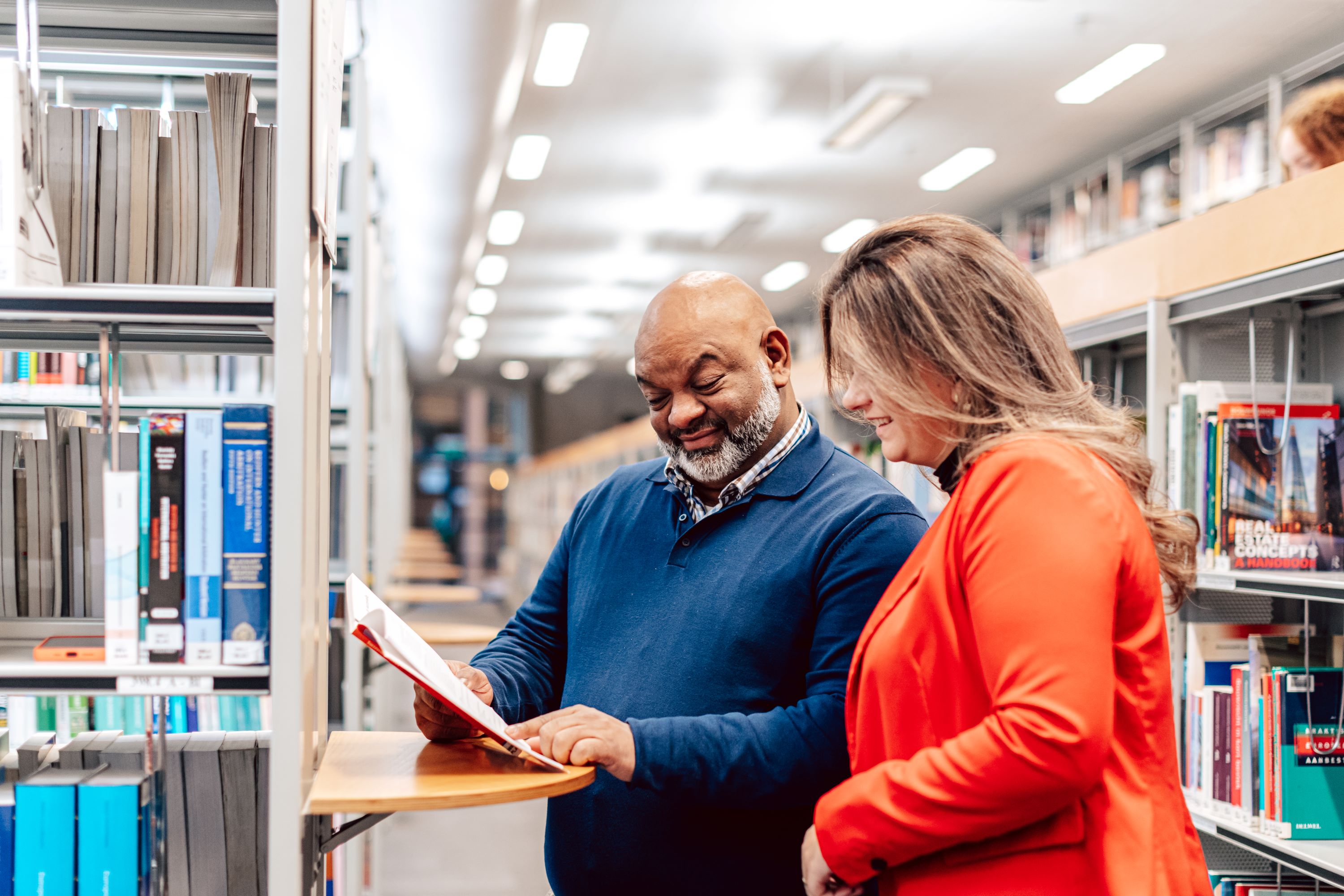 Man en vrouw staan in de bibliotheek