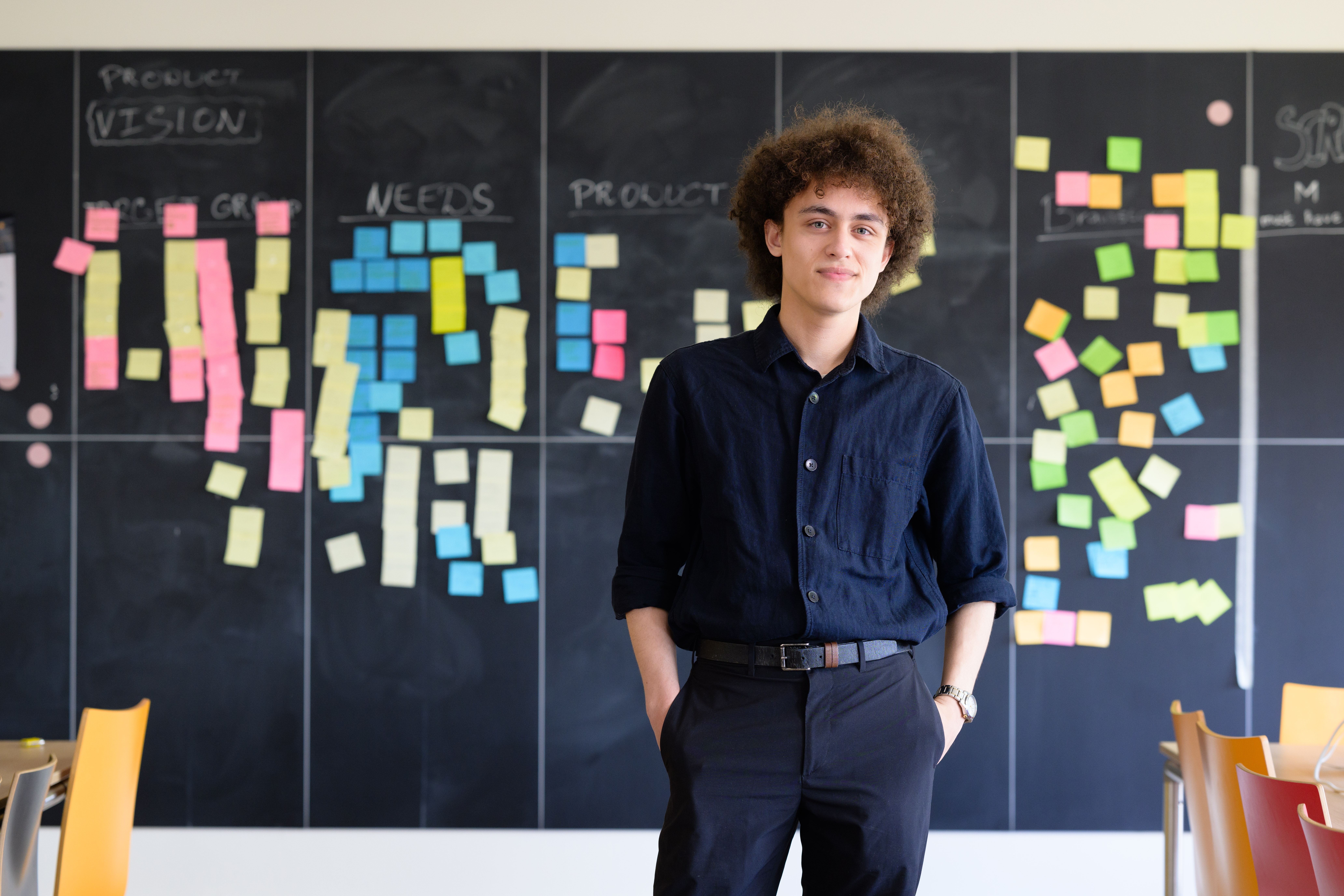 Student staat voor een krijtbord met post-its