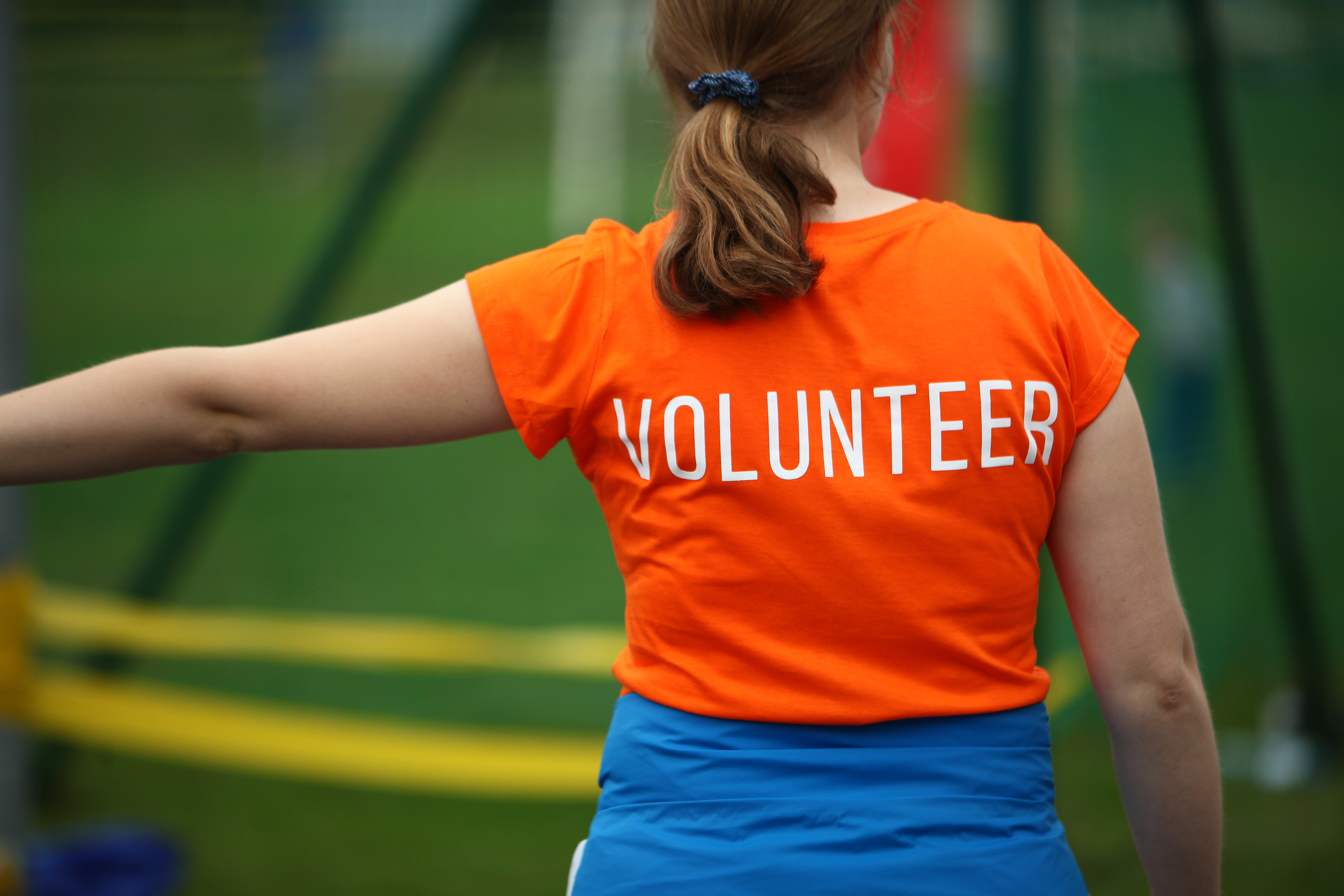 Vrouw met oranje t-shirt met tekst 'Volunteer'