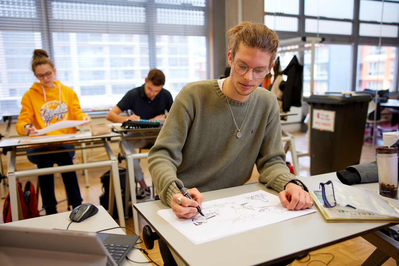 Student design zit achter tekentafel