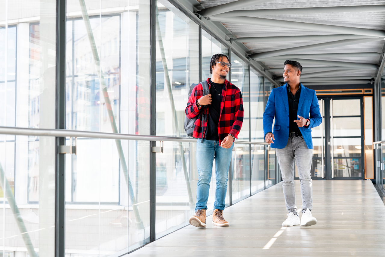 Twee studenten lopen over de brug in De Haagse