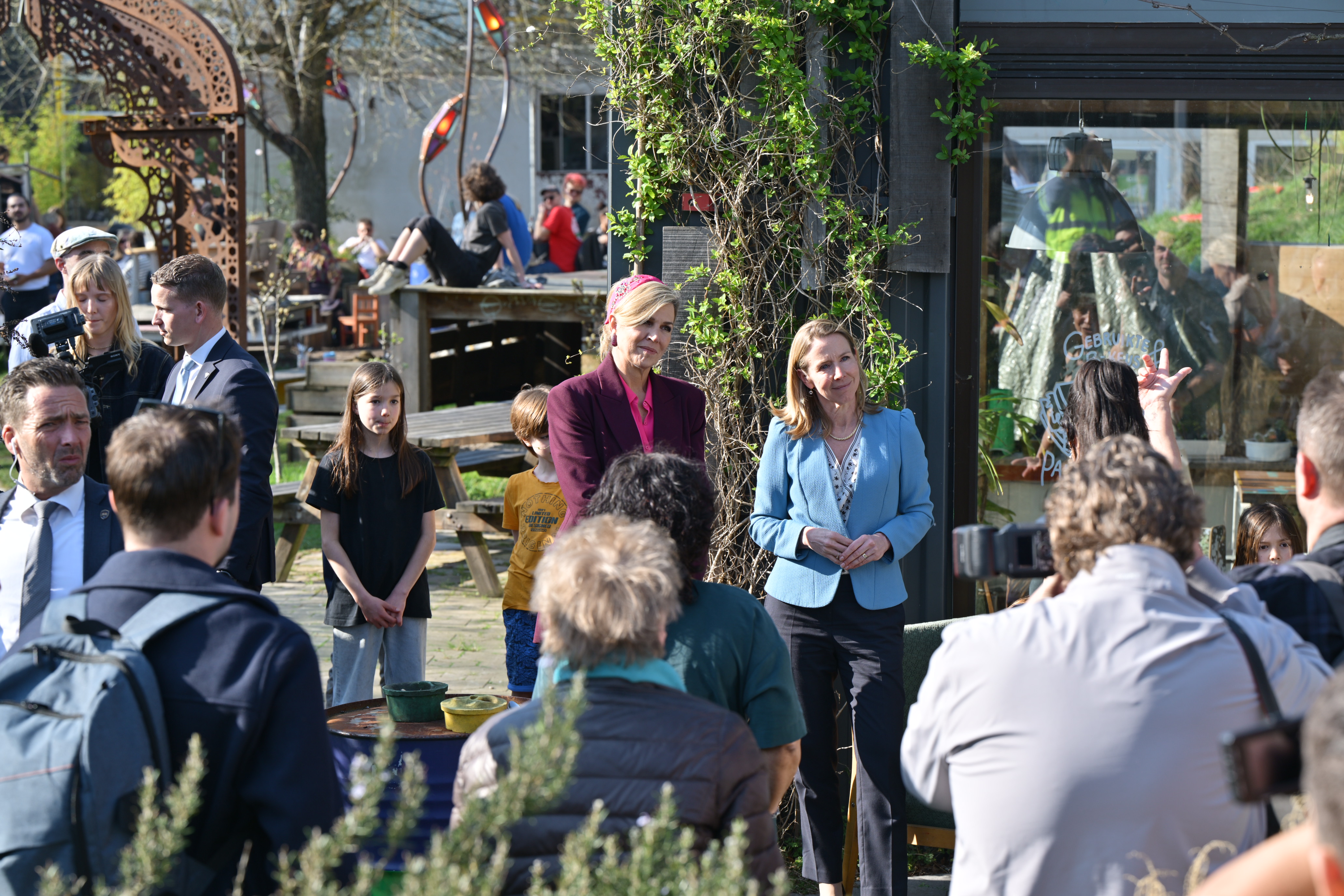 Lector Jenny samen met koningin Maxima spreken voor een groep mensen