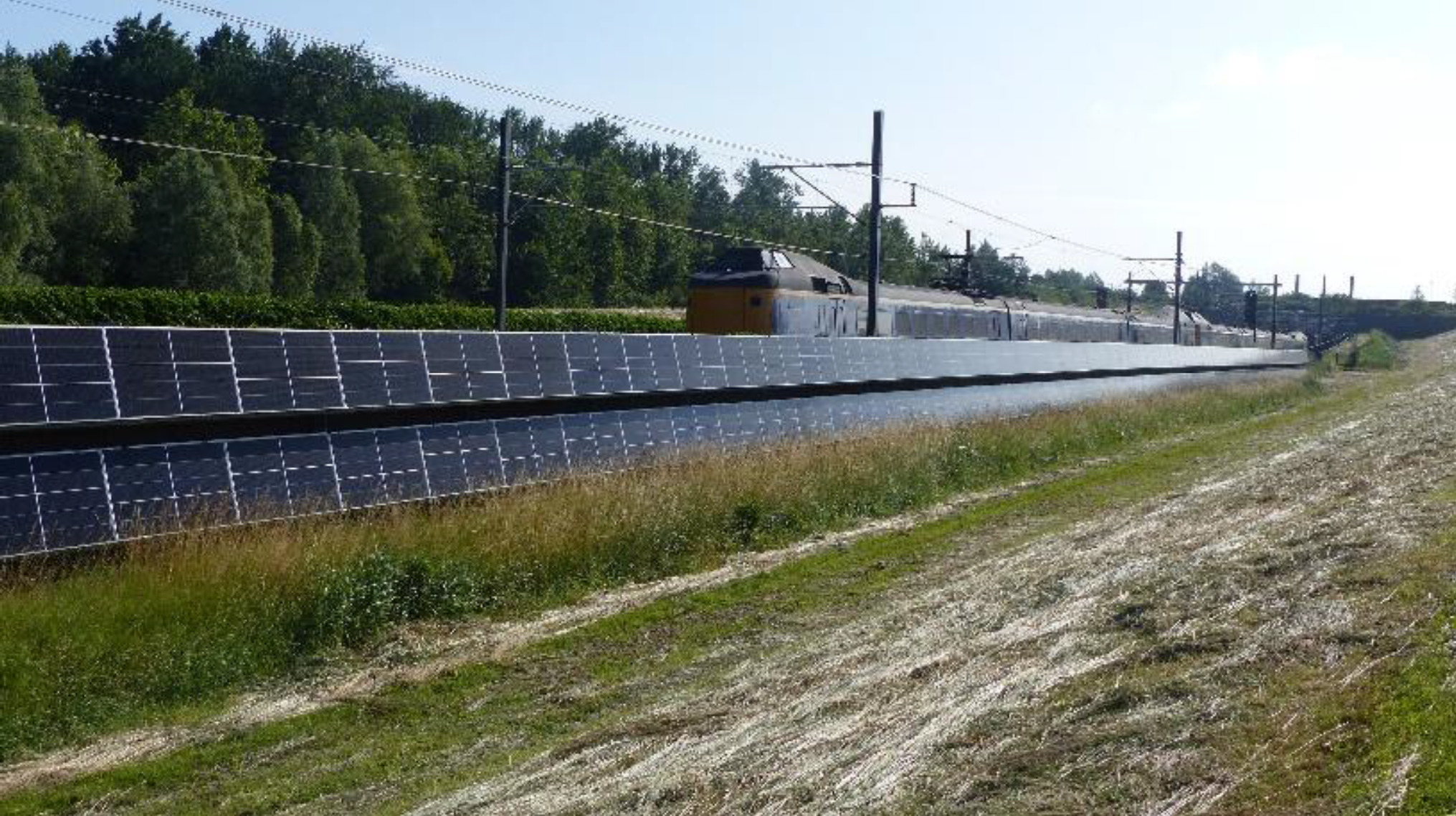 Solar panels along the railway with a passing train.