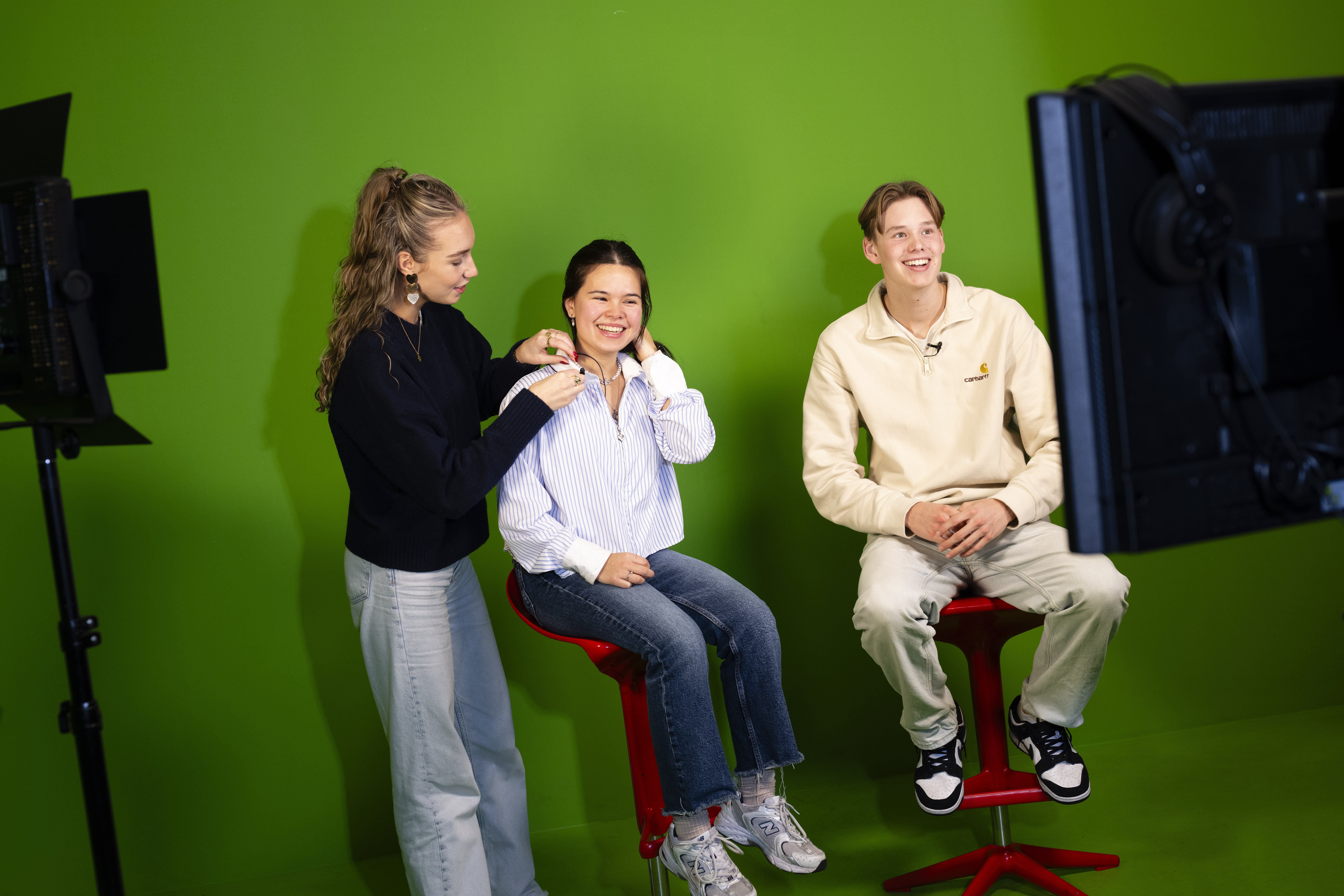 Drie studenten voor een green screen en camera