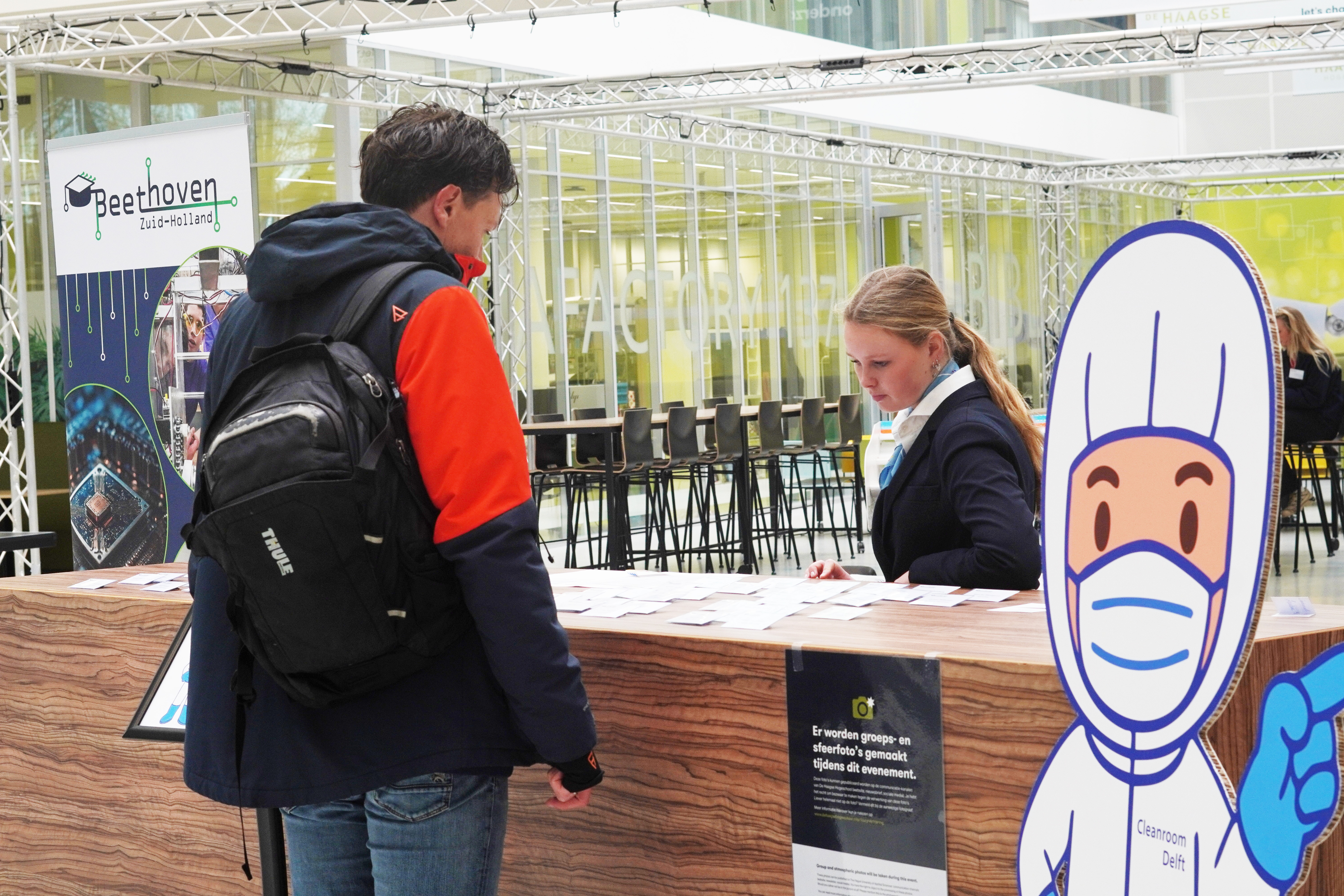 Bezoeker meldt zich aan bij de registratiebalie van een evenement.