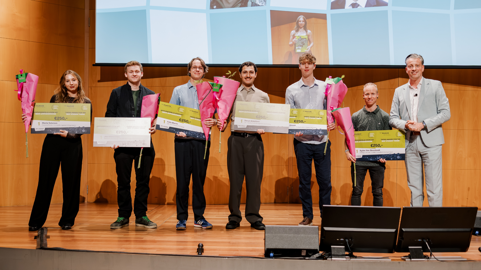 Studenten staan samen op een podium.